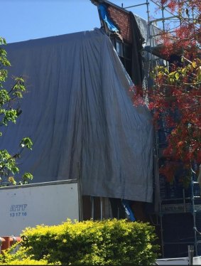 Villanova College's damaged wall at the Veritas Building. The collapsed wall can be seen in a section not covered by the grey tarpaulin.