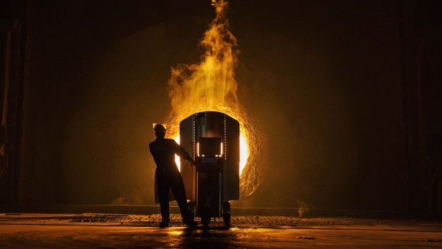  A worker takes samples for quality of molten iron outside a furnace at the Zhong Tian (Steel Group.