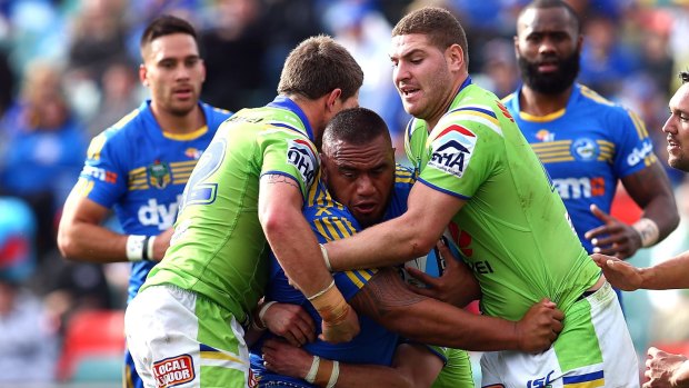 Switching teams: Junior Paulo of the Eels is tackled by the Raiders defence. He's joining Canberra next season.