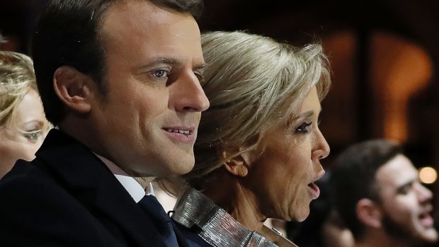 Incoming French President Emmanuel Macron and his wife Brigitte Macron sing the national anthem after he delivered a speech in front of the Pyramid at the Louvre Museum in Paris.