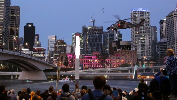 Crowds watch Army Helicopters fly along the Brisbane River during the 2015 Riverfire as part of Brisbane Festival.