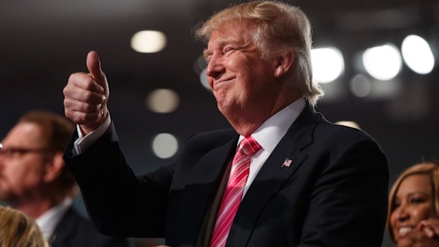 Republican presidential candidate Donald Trump gives a thumbs up during a church service at Great Faith Ministries in Detroit.