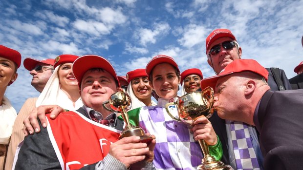 Stevie Payne, left, with sister Michelle, trainer Darren Weir and one of the owners kissing the cup.