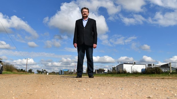 Senator Derryn Hinch in Paynes Road, Rockbank, on Sunday. To his left are sales offices for new homes in the Thornhill Park estate, which is under construction. 