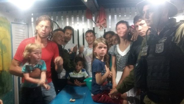 Adam Harteau, left, Emily Harteau, third from right, and their two daughters, with military police officers and residents in Breves, in the northern Brazilian state of Para, on Wednesday.