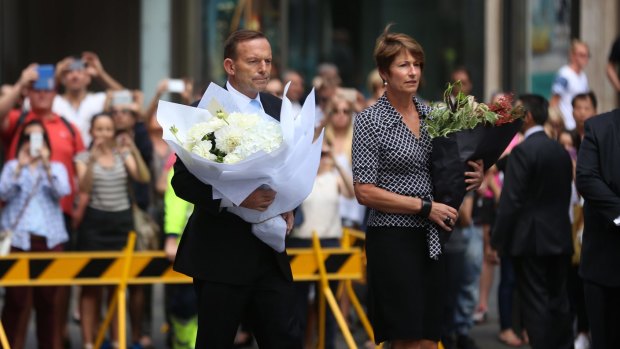 "I'll be doing more": Prime Minister Tony Abbott and his wife Margaret arrive at Martin Place on Tuesday to pay their respects.