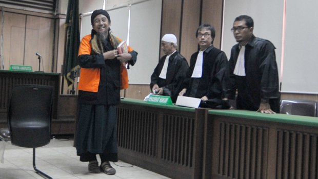 Afief Abdul Madjid, a cleric accused of joining Islamic State and undertaking paramilitary training in Syria, smiles after listening to his verdict in a Jakarta court on June 29.