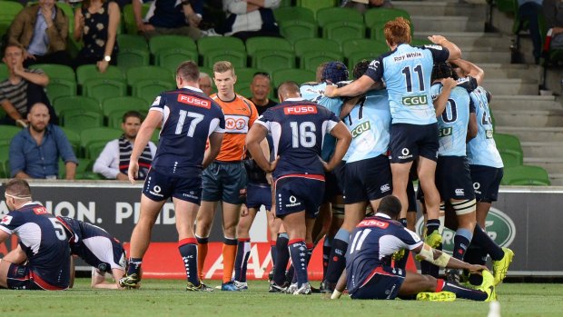The great escape: Waratahs players celebrate after stealing victory against the Rebels.