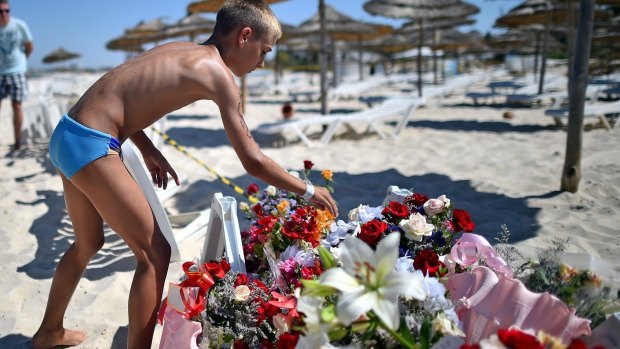 A boy leaves flowers at a memorial on the Tunisian beach where the attack took place.