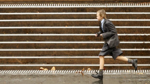 SYDNEY, AUSTRALIA - MAY 31: A school boy runs in the rain on the last day of autumn May 31, 2016 in Sydney, Australia. (Photo by Daniel Munoz/Fairfax Media)