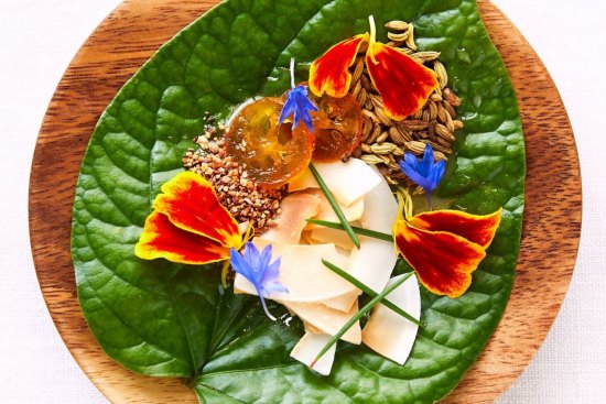 Enter Via Laundry's betel leaf topped with marigold, Geraldton wax and coconut.