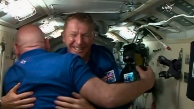 British Flight Engineer Tim Peake of the European Space Agency, centre, hugs Scott Kelly as Peake, Tim Kopra of NASA and cosmonaut Yuri Malenchenko board the International Space Station.