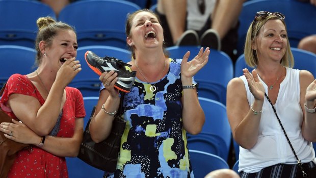 Shoe in: Spectator catches a tennis trainer thrown into the crowd by Alexandr Dolgopolov.