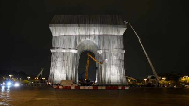 Workers wrap the Arc de Triomphe monument on Wednesday.