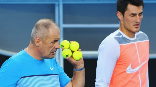 Bernard Tomic listens to his father and coach John Tomic during a practice session before the Australian Open 