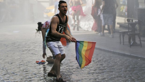 A participant in the Gay Pride parade in Istanbul reacts after Turkish police use a water canon to disperse the crowd. 