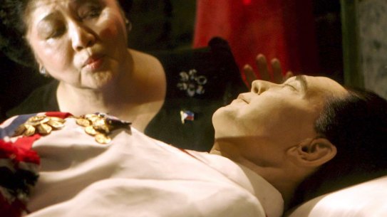 Imelda Marcos kisses the refrigerated crypt of her husband at a mausoleum in Batac, Philippines, in 2005.