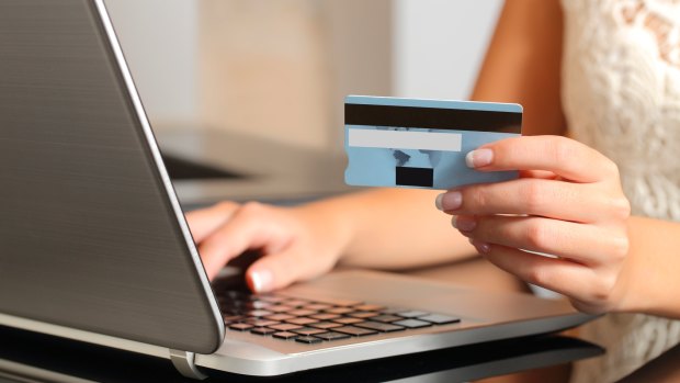 Woman making an online booking with a credit card and a laptop. 
