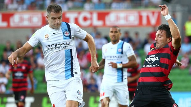 Aaron Hughes of Melbourne City and Federico Piovaccari of the Wanderers compete for the ball.