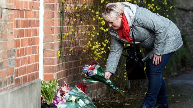 A woman lays flowers outside the Oxfordshire home of the British pop singer.