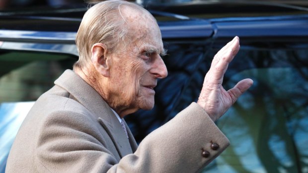 Britain's Prince Philip waves to the public as he leaves after attending the church service.