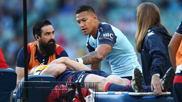 Floored: Israel Folau checked on Reece Hodge as he was taken from the field at Allianz Stadium last weekend.