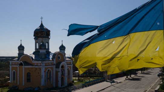MALYN, UKRAINE - MAY 04: An aerial view shows a damaged St. Godmothers Cover Church next to bullet riddled Ukrainian national flag, on May 4, 2022 in Malyn, Ukraine. The communities north of Kyiv were square in the path of Russia's devastating but ultimately unsuccessful attempt to seize the Ukrainian capital with forces deployed from Belarus, a Russian ally. (Photo by Alexey Furman/Getty Images)