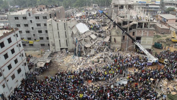 Bangladeshi people gather as rescuers look for survivors and victims at the site of the Rana Plaza collapse in April 2013.
