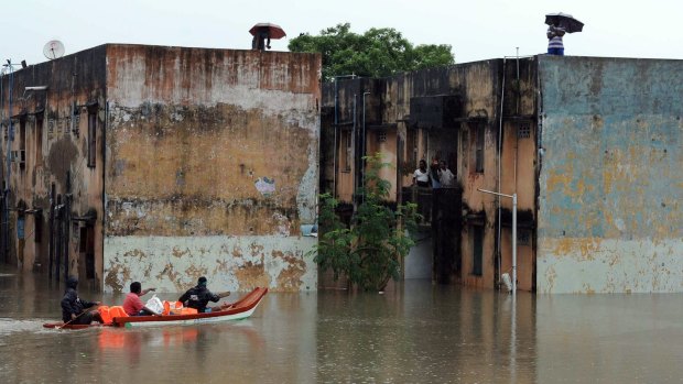 Rescue workers carry food in a boat to distribute to people trapped in a flooded residential area in Chennai, in the southern Indian state of Tamil Nadu.