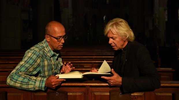 Thomas Schansman (left), the father of MH17 victim Quinn Schansman, looks through the condolence book with Pastor Jules Dresme at St Vitus Church in Hilversum, the Netherlands.  