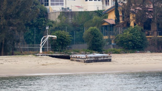 A jetty which was once submerged in water is now planted in sand and sediment, which waterfront lessees say has been washed ashore by RiverCat ferries.