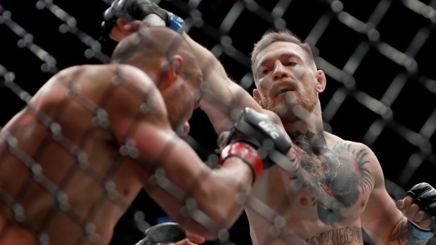 Conor McGregor punches Eddie Alvarez in their UFC lightweight championship fight last November.