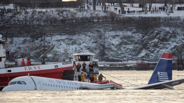 Onlookers line the hillside as rescue workers surround the plane, slowly sinking into the Hudson River. 