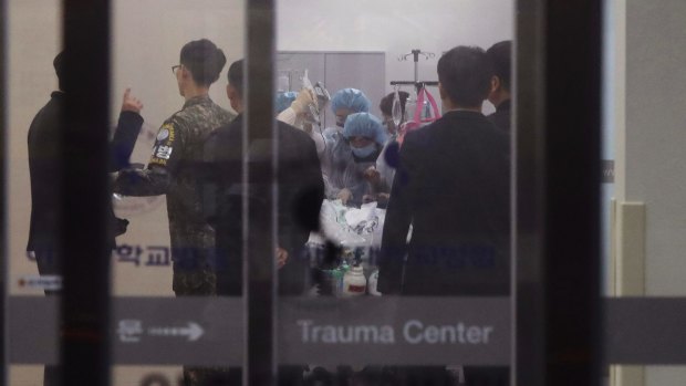 A South Korean army soldier, second from left, is seen as medical members treat an unidentified injured person, believed to be a North Korean soldier, at a hospital in Suwon, South Korea.