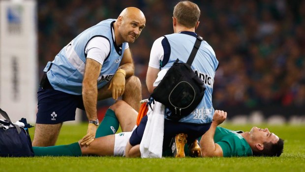 Sidelined: Jonathan Sexton receives treatment in the pool game against France.