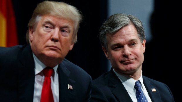 President Donald Trump sits with FBI Director Christopher Wray during the FBI National Academy graduation ceremony in Quantico, Virginia.