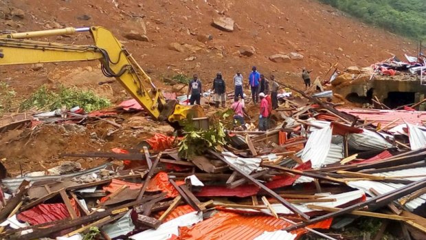 People survey the damage after mudslides in Regent.