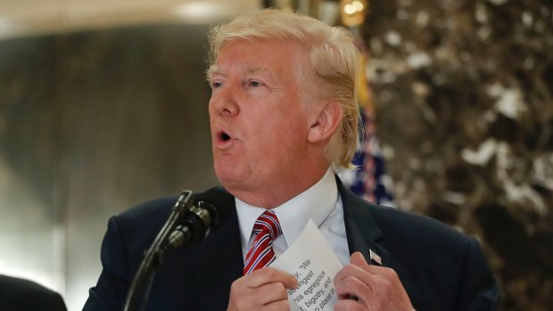 President Donald Trump reaching into his suit jacket to read a quote he made on Saturday.