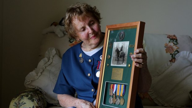 Stella Curran with a framed photo and medals of her father Alan Crawford Lindsay. The 91-year-old proudly wears medals and a jacket with buttons from her father's military uniform every ANZAC day. 