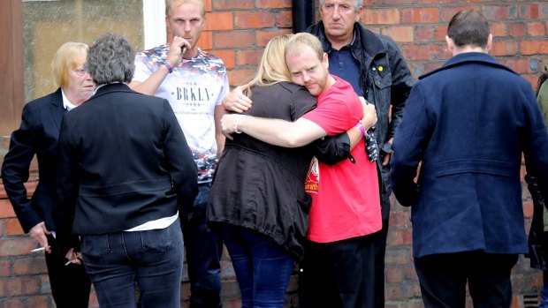 Family members hug after being told charges have been laid against six people over the Hillsborough tragedy.