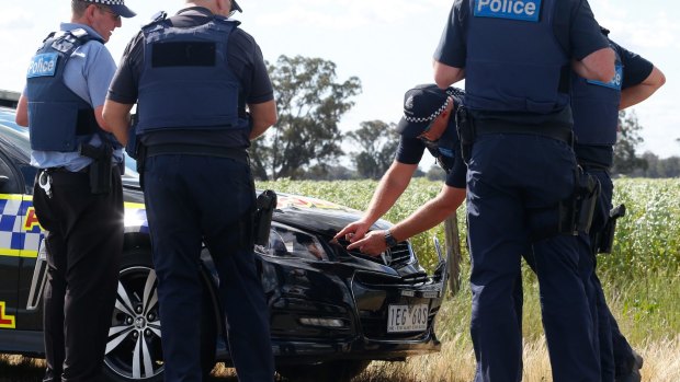 Police examine damage to a highway patrol car that they now say may have been rammed by the Stoccos in St James west of Wangaratta.