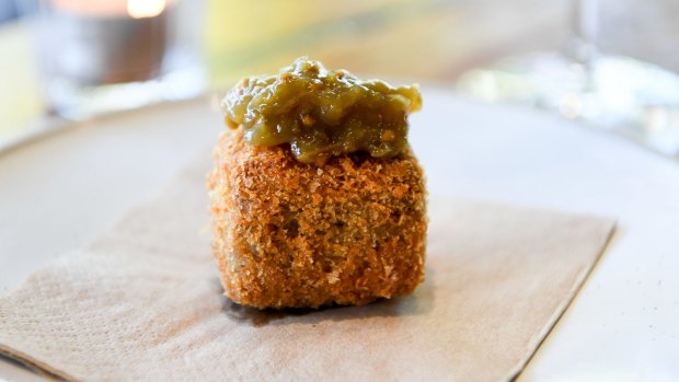 Fried terrine is a perfect golden puck crowned with elegant green tomato relish.