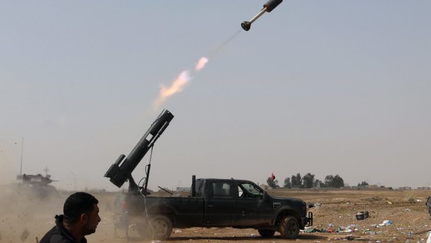 Iraqi security forces launch a rocket against Islamic State extremist positions during clashes in Tikrit on March 30.