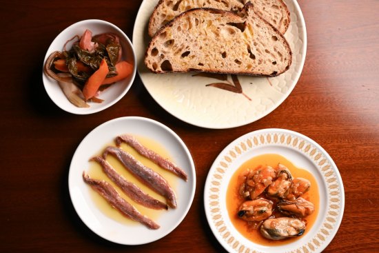 Clockwise from top right: House-baked sourdough bread with mussels
escabeche, anchovies and pickles.