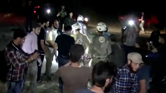 Civil Defence workers stand in the rubble after air strikes hit a hospital in Aleppo.