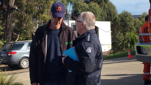 David Curry speaks to a police officer at Aireys Inlet, where his wife Elisa went missing.