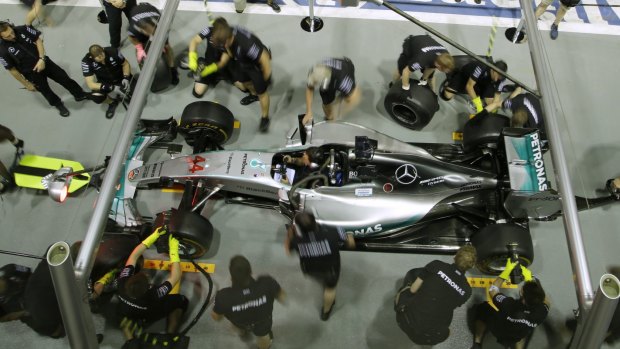 Team mechanics for Mercedes driver Lewis Hamilton of Britain practice tire changes.