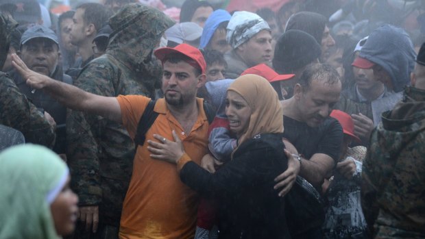 A woman weeps as she and hundreds of others are stopped in pouring rain at the border between Greece and Macedonia on Thursday.