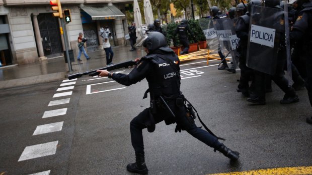 Spanish riot police fire rubber bullets trying to stop people reaching a voting site.
