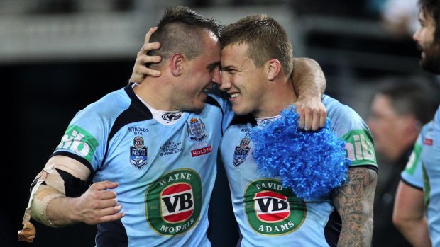 A game of two halves: Josh Reynolds and Trent Hodkinson share a moment after winning back the Origin trophy last year.